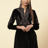 The girl is in charcoal black velvet kurti with gold dori, sequin highlights, mandarin collar, and full sleeves.