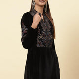 LakshitaÃ¢â‚¬â„¢s elegant velvet kurti is represented by a model with colourful floral patterns, and gold dori highlights.