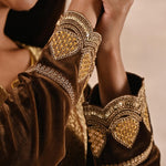 The woman in the image shows heavy designer work in sleeves of Golden Velvet Kurta 