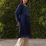 Wearing Lakshita’s Navy Blue Embroidered Cotton Gauze Kurta, the model strikes a graceful side pose