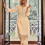 A woman is posing with Grace ivory embroidered cotton kurta, keeping her hand on the door