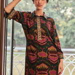Woman wearing emerald green printed rayon co-ord set with intricate gold embroidery on neckline and cuffs.