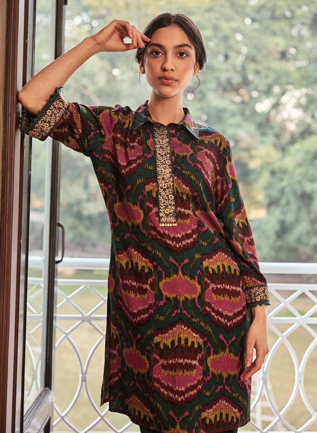 Woman wearing emerald green printed rayon co-ord set with intricate gold embroidery on neckline and cuffs.