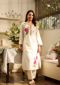 Front view of Lakshita Ulfat Pearl Ivory Set with pink rose embroidery on chest and hem, showcasing cotton linen fabric.