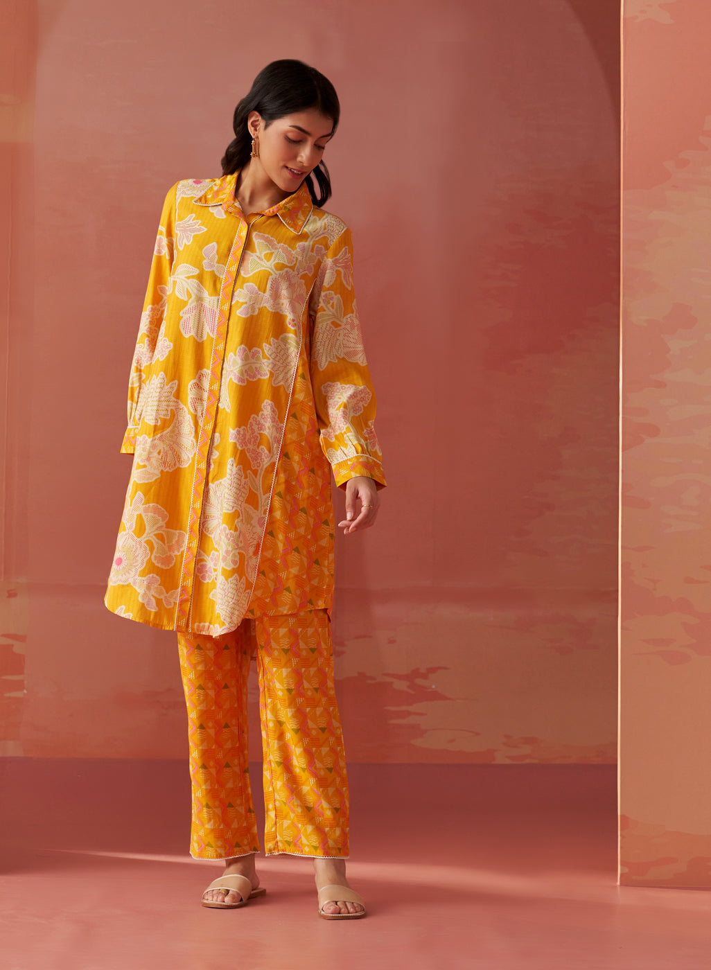 Back view of Seher bright yellow printed Chanderi co-ord set featuring floral patterns on long kurta and matching pants.