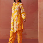 Angled profile of yellow floral printed Chanderi co-ord set for women with long collared kurta and straight printed pants.