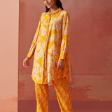 Model in side pose wearing bright yellow printed Chanderi co-ord set with collared kurta and geometric printed pants.