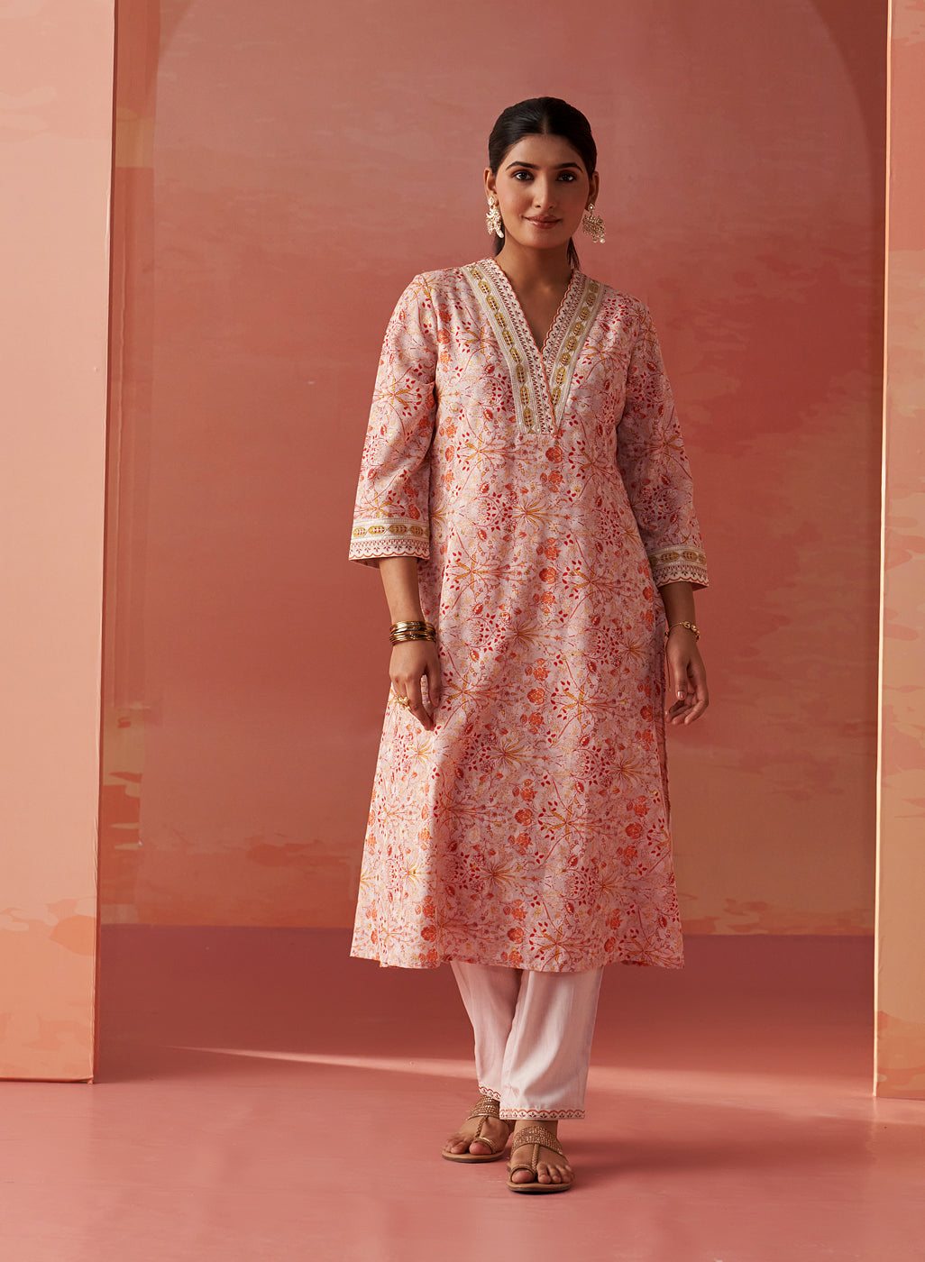 The model is posing with Lakshita's Rumaisa Orange Printed Chanderi Jacquard Co-ord Set