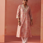 The model is posing with Lakshita's Rumaisa Orange Printed Chanderi Jacquard Co-ord Set