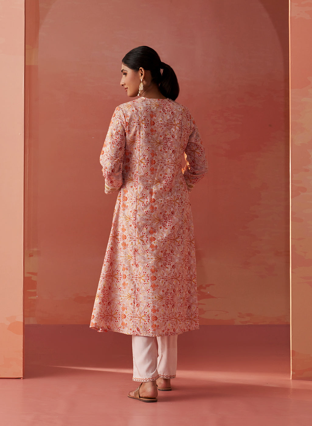 The image features the back view of the model with  Lakshita’s Rumaisa Orange Printed Chanderi Co-ord Set