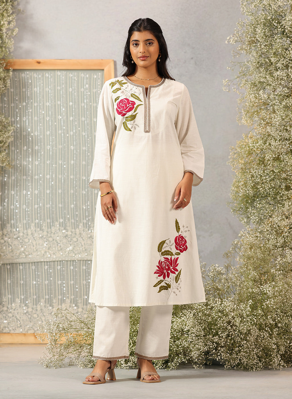 Lakshita Ulfat Ivory Kurta Set in front view showing elegant pink floral motifs on one chest side and hemline.