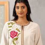 Detailed view of Lakshita Ulfat Ivory Kurta highlighting pink floral chest embroidery and zari-trimmed neckline.
