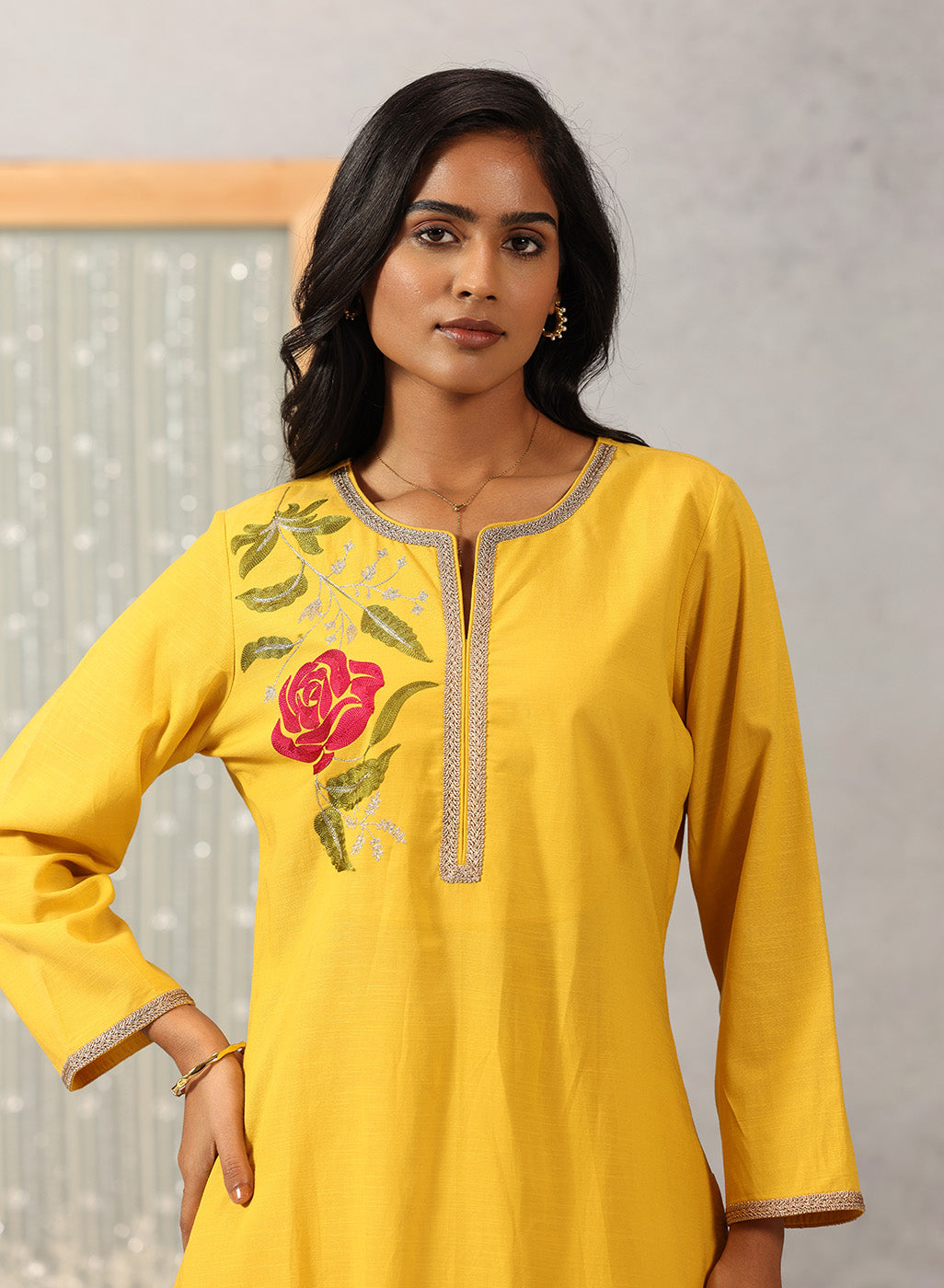 Waist-up close-up of Lakshita Ulfat Yellow Kurta Set showing red rose embroidery on the chest with zari accents.