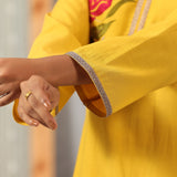Close-up of Lakshita Ulfat Yellow Kurta sleeve showcasing zari lace trim on the cuff and soft cotton linen fabric.