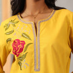 Close-up of chest detail on Lakshita Ulfat Yellow Kurta featuring red silk thread rose motif and zari lace neckline.