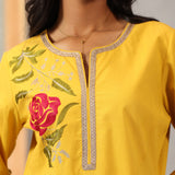 Close-up of chest detail on Lakshita Ulfat Yellow Kurta featuring red silk thread rose motif and zari lace neckline.