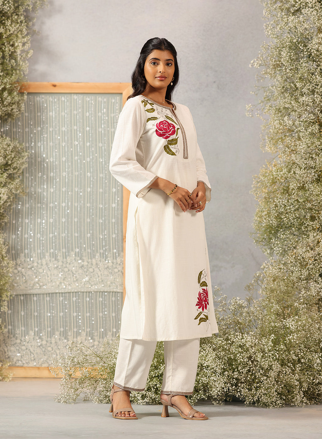 Model in Lakshita Ulfat Pearl Ivory Kurta Set turned sideways, showing floral embroidery and drape of cotton linen fabric.