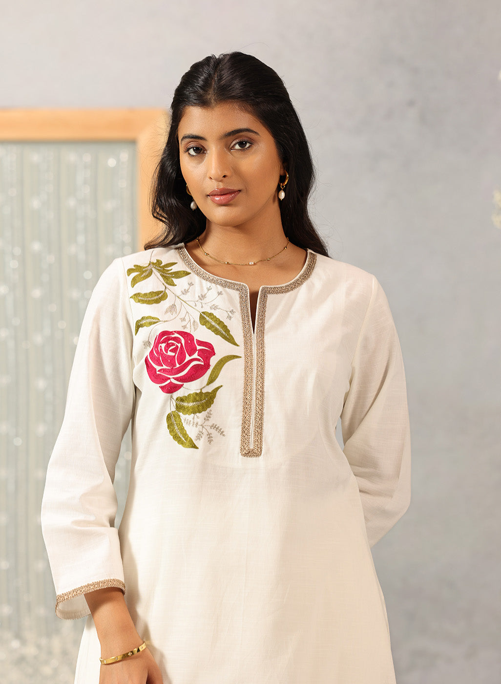 Close-up waist-up view of Ulfat Pearl Ivory Kurta Set, highlighting pink rose embroidery on soft cotton linen fabric.