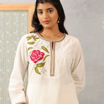Close-up waist-up view of Ulfat Pearl Ivory Kurta Set, highlighting pink rose embroidery on soft cotton linen fabric.