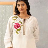 Close-up waist-up view of Ulfat Pearl Ivory Kurta Set, highlighting pink rose embroidery on soft cotton linen fabric.