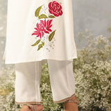 Waist-down view of Ulfat Pearl Ivory Kurta with pink rose motif on edge and zari-detailed hem of solid cotton linen pants.