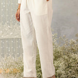 Close-up side shot of Ulfat set's ivory straight pants showcasing clean lines, slit pockets, and subtle zari hem detailing.