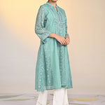 Woman in Fariha Carnation Green Embroidered Raschel Net Dress and white palazzos