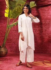 Side view of the model wearing Inaya ivory embroidered cotton linen slub kurta, highlighting detailed embroidery design.