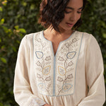 A close up view of ivory embroidered cotton gauze kurta, highlighting neckline
